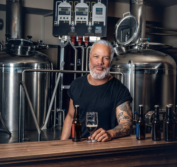 Variller ve bira şişeleri etrafında profesyonel yaşlı bira üreticisi.