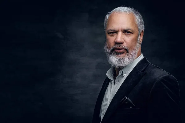 Elderly man dressed in black tuxedo against dark background — Foto Stock