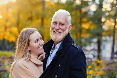 Huzurlu sonbahar ormanında kıdemli adam ve torunu.