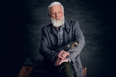 Eski moda fotoğrafçı karanlık arka planda poz veriyor.