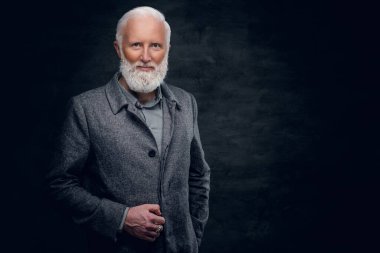 Gri elbiseli neşeli büyükbaba kameraya bakıyor.