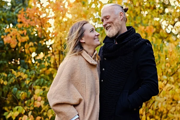 Couple of elderly man and young woman in autum — стоковое фото