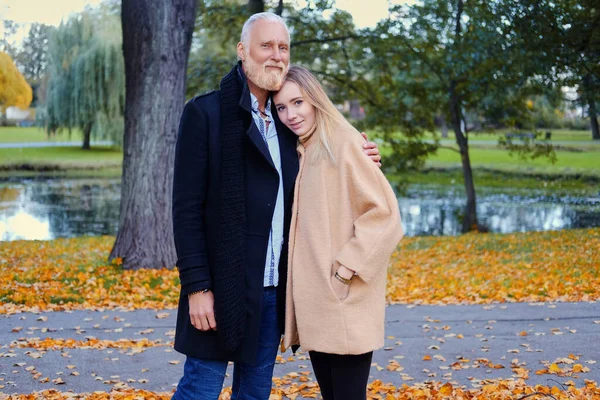 Senior man and his daughter on walk in autumnal park — стоковое фото
