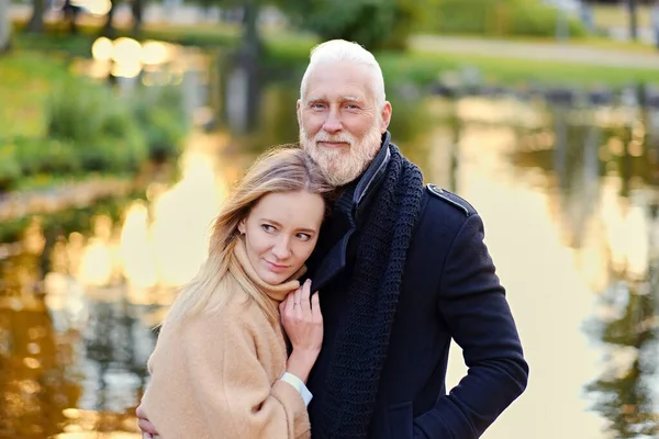 Senior man and his granddaughter in peaceful autumnal forest — стоковое фото