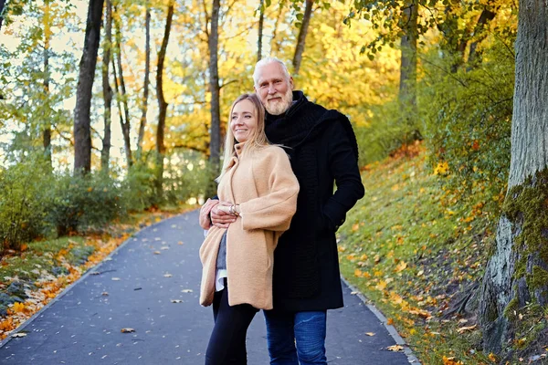 Cheerful granddaughter and grandfather on walk in autumnal wood Rechtenvrije Stockfoto's