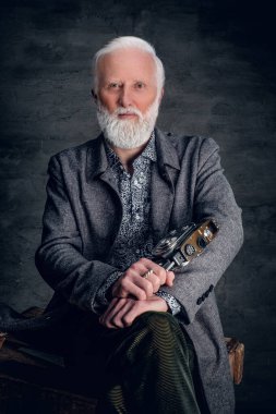 Eski moda fotoğrafçı karanlık arka planda poz veriyor.