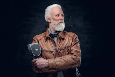 Eski moda fotoğrafçı karanlık arka planda poz veriyor.