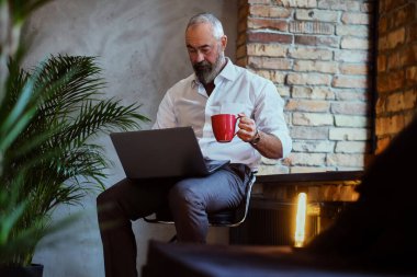 Ofiste kahve fincanı tutarken dizüstü bilgisayar kullanmak çok ciddi.