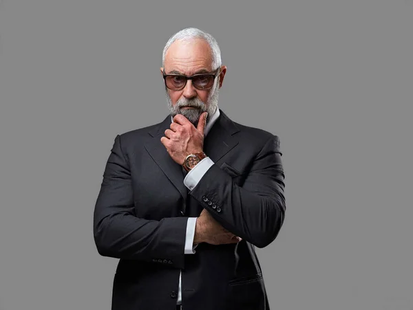 Pensiv gammal affärsman med solglasögon mot grå bakgrund — Stockfoto