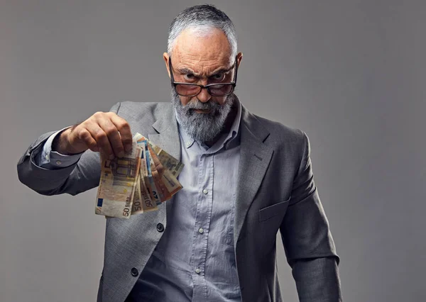 Rich elderly business person dressed in suit holding money — 스톡 사진