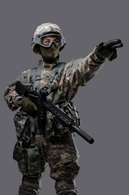 Modern koruyucu üniforma giymiş asker kadın işaret ediyor.