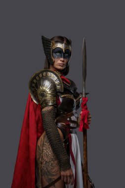 Kırmızı pelerinli ve mızraklı dövmeli kadın savaşçı.