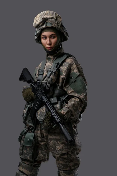 Військова жінка з рушницею одягнена в камуфляжний костюм — стокове фото