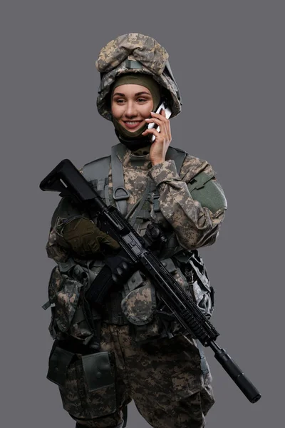 Mulher militar feliz com celular contra fundo cinza — Fotografia de Stock