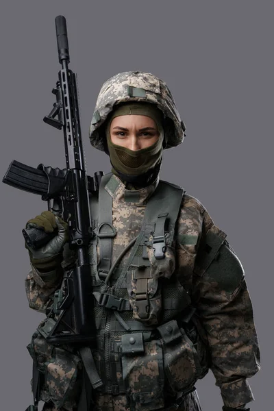 Professionele militante vrouw met geweer geïsoleerd op grijze achtergrond — Stockfoto