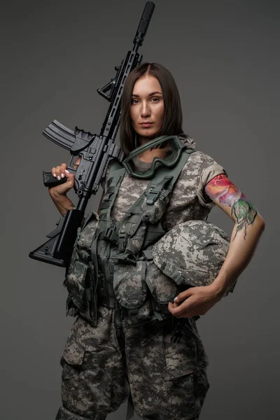 Mulher soldado atraente com rifle contra fundo escuro — Fotografia de Stock