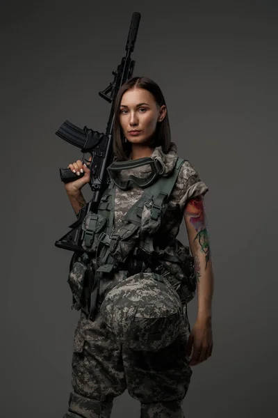 Mulher de cabelos castanhos segurando rifle em seu ombro — Fotografia de Stock