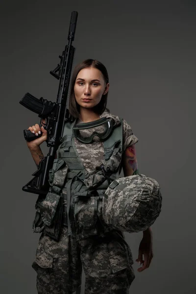 Brun hårig kvinna håller gevär på axeln — Stockfoto