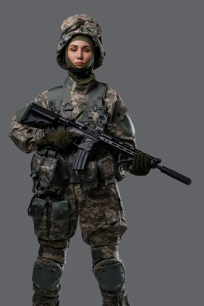 Proud woman with rifle posing against gray background — Stock Photo, Image