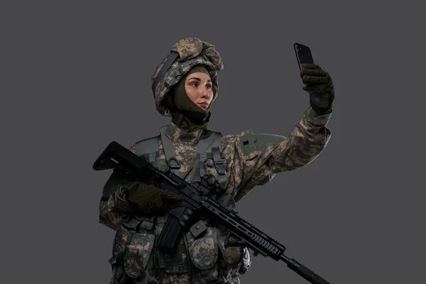 Vrouw special forces soldaat maken selfie tegen grijze achtergrond — Stockfoto