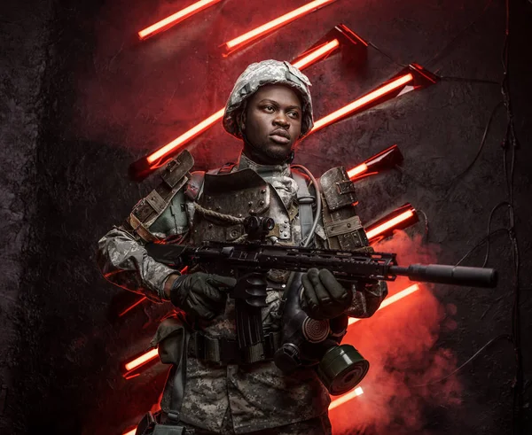 赤ネオンを背景に 黙示録的なスタイルでライフルでアフリカ民族の軍隊の兵士のショット — ストック写真