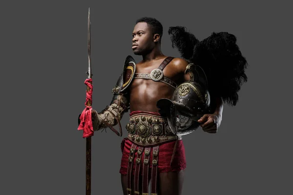 Gri Arka Planda Tüylü Miğfer Mızrak Tutan Afrikalı Gladyatör Portresi — Stok fotoğraf