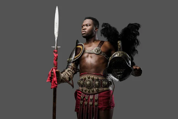 Gri Arka Planda Tüylü Miğfer Mızrak Tutan Afrikalı Gladyatör Portresi — Stok fotoğraf