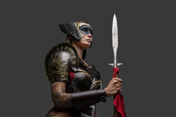 工作室拍摄的迷人的女野蛮人身穿盔甲 头戴头盔 手持长矛 — 图库照片