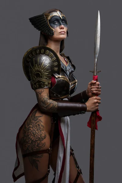 开枪射击身穿钢甲 手持长矛 身披灰色背景的古代女战士 — 图库照片