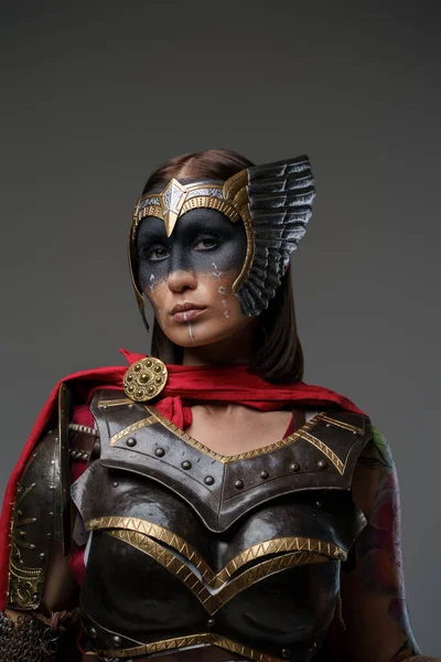 濃紺の鎧を着た女性戦士の顔と赤いケープのショット — ストック写真