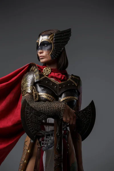 灰色の背景にヘルメットと鎧を着たスカンディナヴィアの戦士の女性のショット — ストック写真