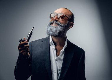 Takım elbise giymiş, güneş gözlüğü takmış, sigara içen son sınıf öğrencisinin portresi..