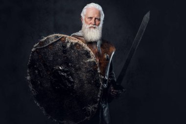 Zincirli zırhlı, zırhlı ve kılıçlı yaşlı şövalyenin stüdyo fotoğrafı..