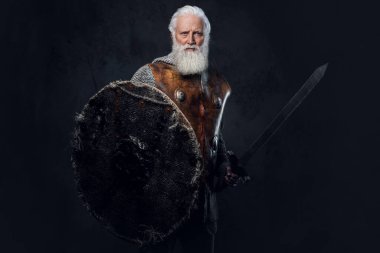 Zincirli zırhlı, zırhlı ve kılıçlı yaşlı şövalyenin stüdyo fotoğrafı..