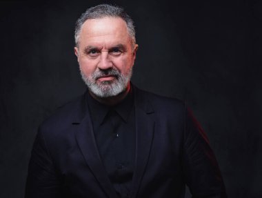 Siyah giyinmiş yakışıklı yaşlıların portresi. Siyah arka planda şık saç stilleri var..