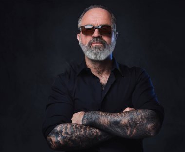 Siyah gömlekli, güneş gözlüklü ve dövmeli vahşi yaşlı maço portresi..