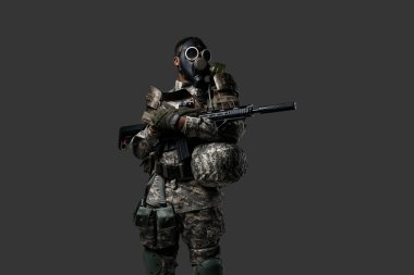 Siyah askerin koruyucu gaz maskesi ve kamuflaj kıyafetleri içindeki stüdyo fotoğrafı..