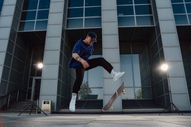 Yetenekli kaykaycının portresi kaykayının üzerine atlıyor..