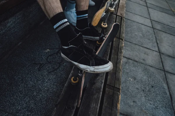 여름에 벤치에 보드를 스케이트 보더들의 다리를 — 스톡 사진