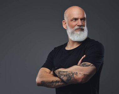 Siyah tişörtlü ve elleri dövmeli kendine güvenen yaşlı bir sporcunun portresi..