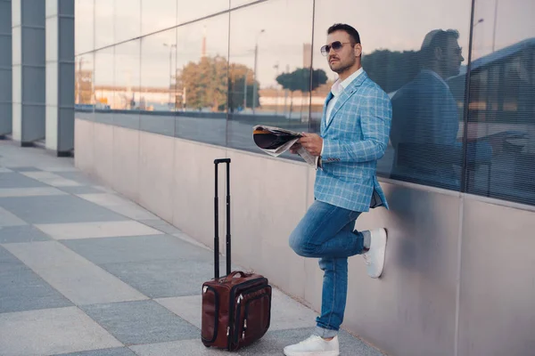 Portrait Fashionable Man Suitcase Reading Newsletter Leaning City Building — Foto de Stock
