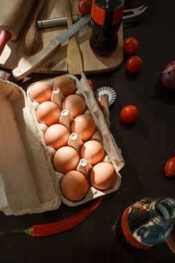 Shot of some veggies and eggs at table in kitchen. Ingredients of future pizza.