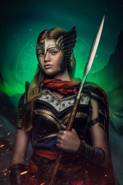 Shot of scandinavian woman warrior with spear dressed in armor and mantle.