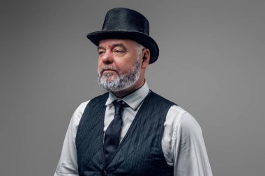 Geçmişten kalma şık ve silindir şapkalı yaşlı bir adamın stüdyo fotoğrafı..