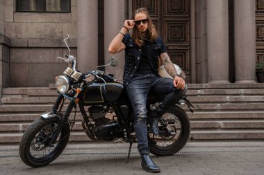 Sakallı ve uzun saçlı motosikletli vahşi motosikletli..