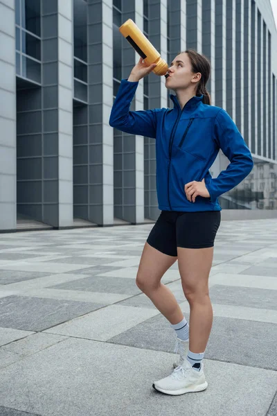 Πυροβολισμός Αθλητική Γυναίκα Ντυμένη Αθλητικά Ρούχα Πόσιμο Νερό Ετοιμάζεται Τρέξει — Φωτογραφία Αρχείου
