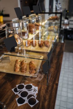 Bir kafe barında gündüz şekerli kruvasan ve kahve var..