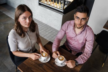 Sevgilisiyle birlikte modern kahve dükkanında kahve içerken çekilmiş bir fotoğraf..