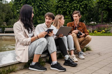 Yaz mevsiminde birlikte kamu parkında vakit geçiren arkadaşların portresi.