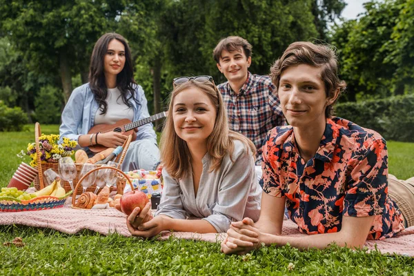 Retrato Cuatro Jóvenes Amigos Teniendo Tiempo Juntos Picnic Con Algo —  Fotos de Stock